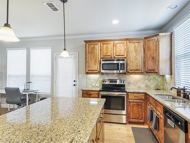 2500 Rockbrook Dr Unit 81, Lewisville, TX 75067 - kitchen featuring brown cabinetry, visible vents, light wood-type flooring, a sink, and stainless steel appliances