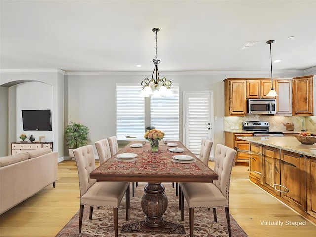 2500 Rockbrook Dr Unit 81, Lewisville, TX 75067 - dining space featuring a notable chandelier, visible vents, ornamental molding, and light wood finished floors
