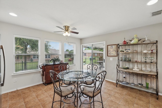 dining area with visible vents, a ceiling fan, baseboards, and a wealth of natural light