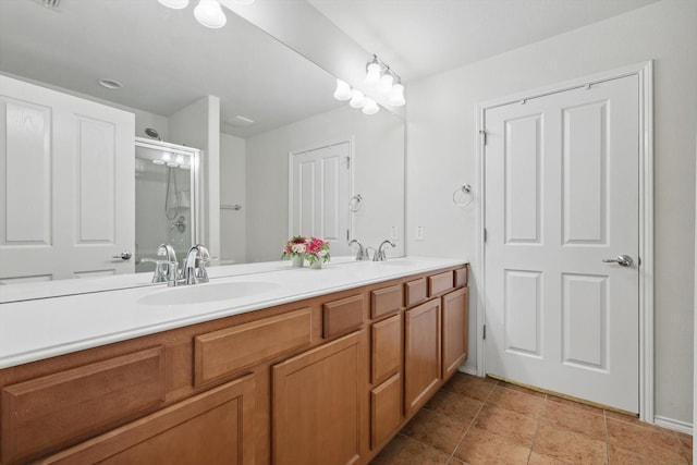 full bathroom with double vanity, a sink, and a shower with shower door