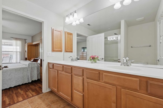 bathroom with a sink, ensuite bath, double vanity, visible vents, and a stall shower