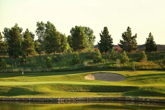 view of property's community with view of golf course and a yard