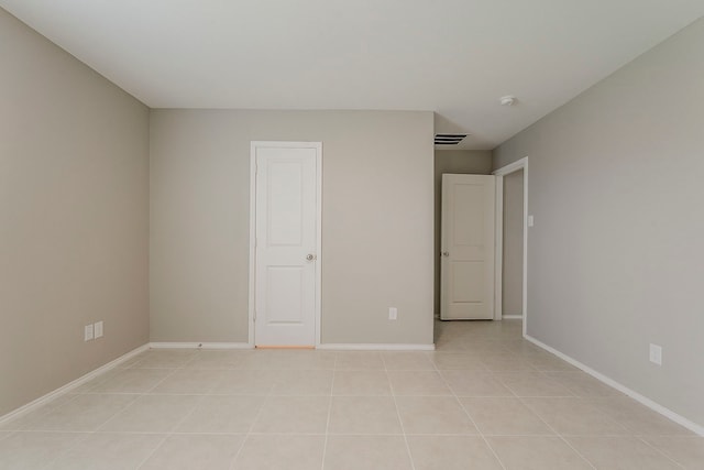 unfurnished bedroom featuring baseboards, light tile patterned flooring, and visible vents