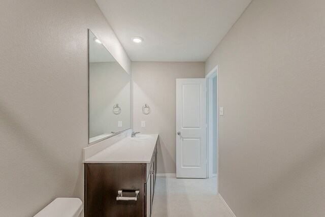 bathroom featuring vanity, baseboards, and toilet