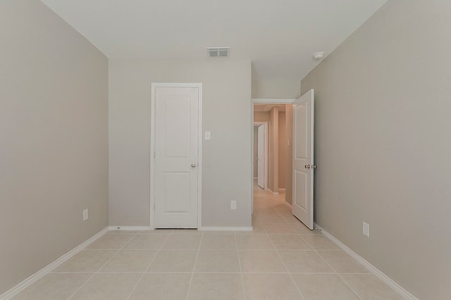 unfurnished bedroom featuring baseboards, visible vents, and light tile patterned floors