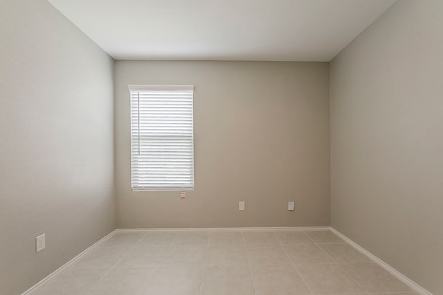 unfurnished room with light tile patterned flooring and baseboards