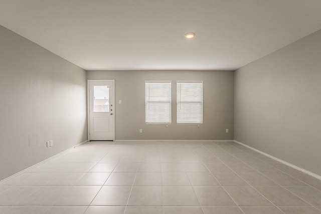 spare room with baseboards and light tile patterned floors
