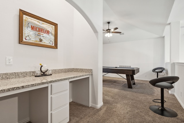 interior space featuring a ceiling fan, vaulted ceiling, dark colored carpet, and visible vents