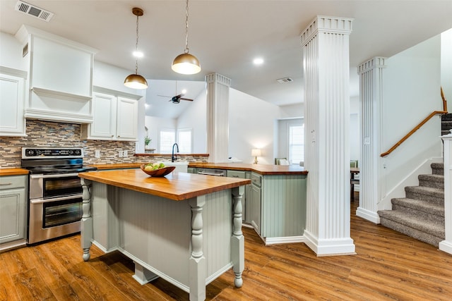 9816 Hedge Bell Dr, Mckinney, TX 75072 - kitchen with visible vents, decorative backsplash, butcher block counters, wood finished floors, and appliances with stainless steel finishes