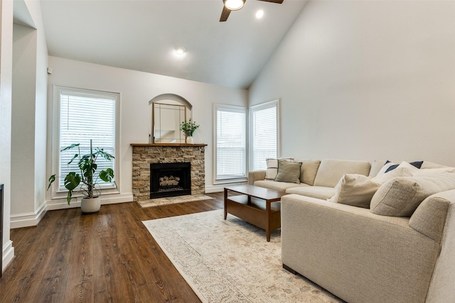 9816 Hedge Bell Dr, Mckinney, TX 75072 - living area with a stone fireplace, ceiling fan, a wealth of natural light, and dark wood-style floors