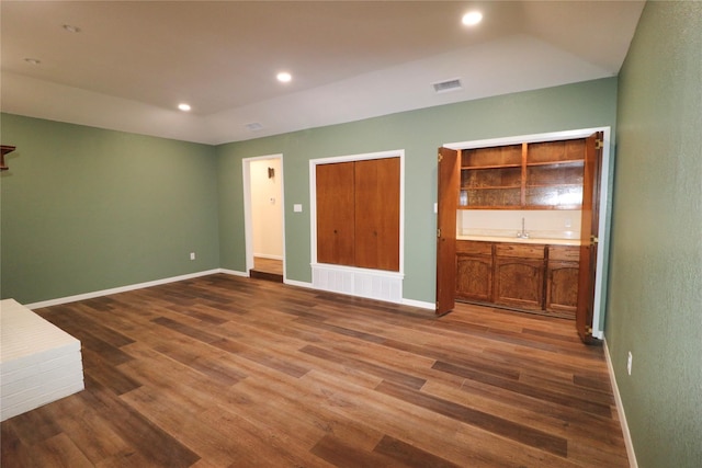 unfurnished living room featuring baseboards, visible vents, and wood finished floors