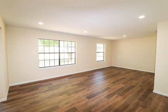 spare room featuring plenty of natural light, dark wood-style flooring, and recessed lighting