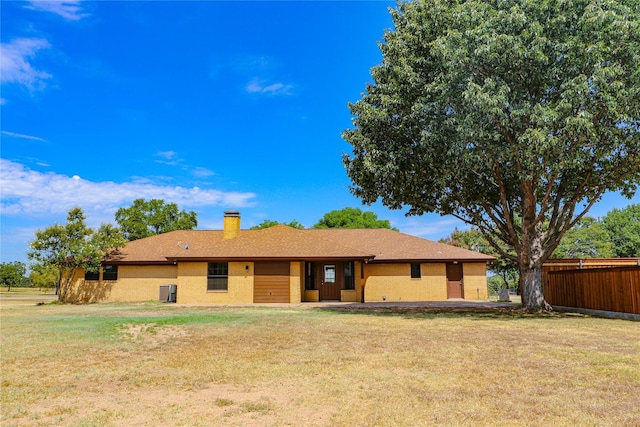 view of front of home with a chimney, a front lawn, and fence