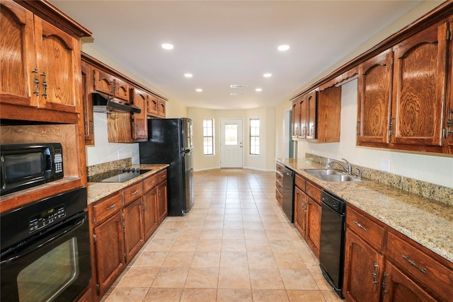 kitchen featuring under cabinet range hood, recessed lighting, black appliances, and a sink