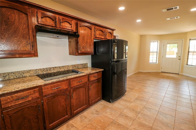 kitchen featuring under cabinet range hood, visible vents, baseboards, and black appliances