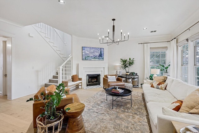 living area with stairs, recessed lighting, a fireplace with flush hearth, and ornamental molding