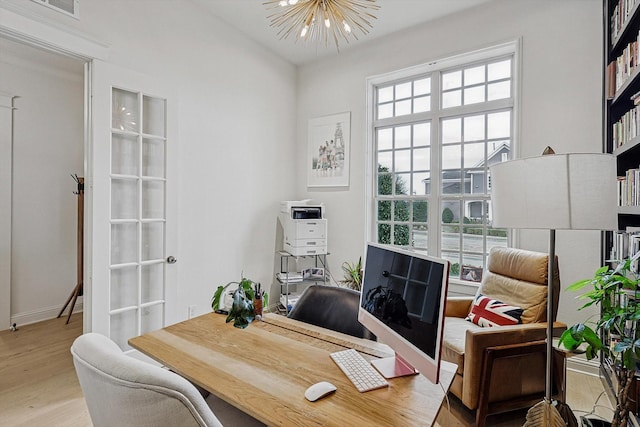 office area featuring plenty of natural light, baseboards, wood finished floors, and a chandelier
