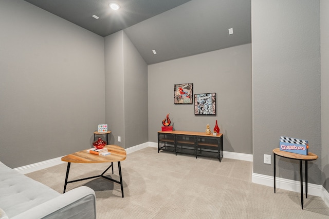 living area featuring baseboards, vaulted ceiling, and light carpet