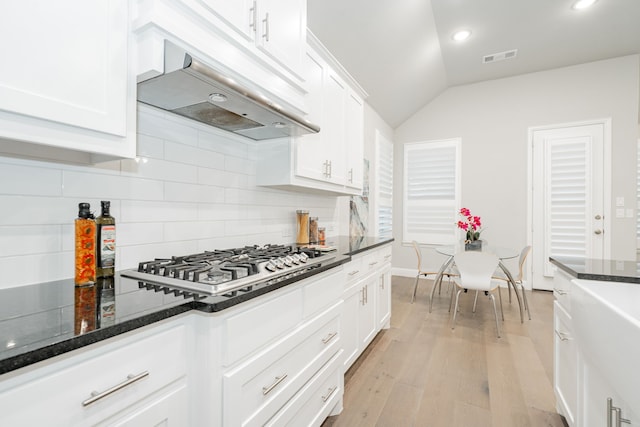 kitchen with tasteful backsplash, stainless steel gas cooktop, light wood-type flooring, white cabinets, and under cabinet range hood