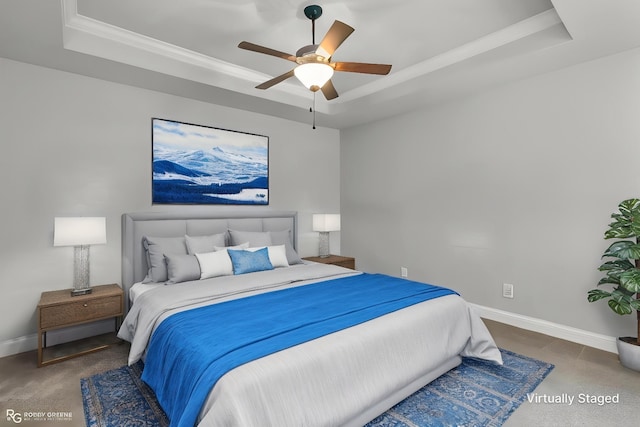 bedroom featuring baseboards, carpet flooring, a raised ceiling, and crown molding