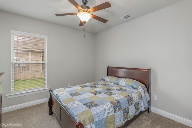 carpeted bedroom with baseboards, visible vents, and multiple windows