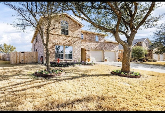 traditional-style house featuring fence, an attached garage, driveway, and brick siding