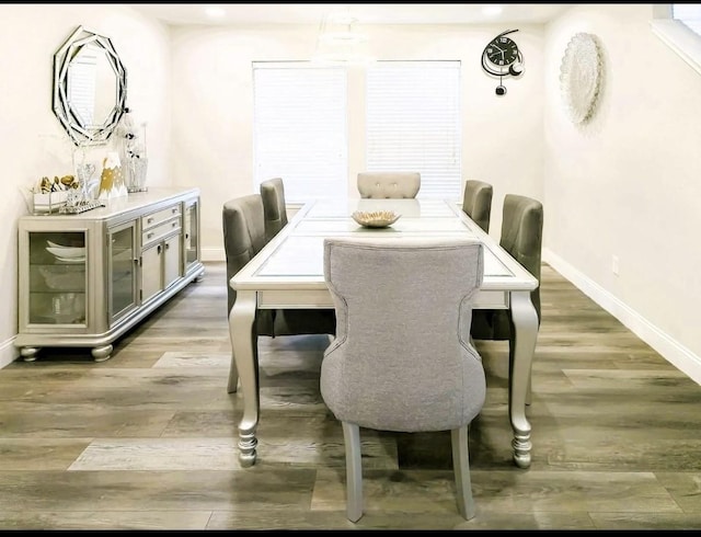 dining area featuring baseboards and light wood finished floors