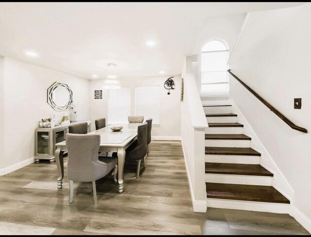 dining area featuring baseboards, recessed lighting, stairs, and light wood finished floors