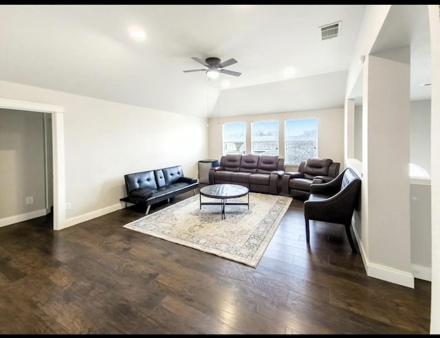 living area with visible vents, dark wood-style flooring, baseboards, ceiling fan, and vaulted ceiling