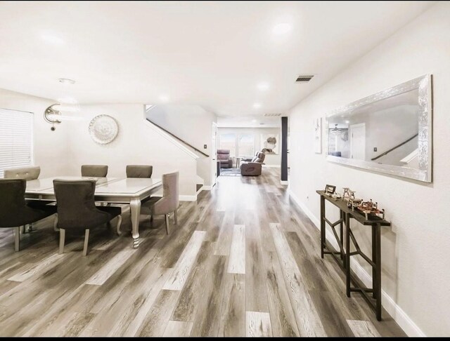 dining area with visible vents, baseboards, and wood finished floors