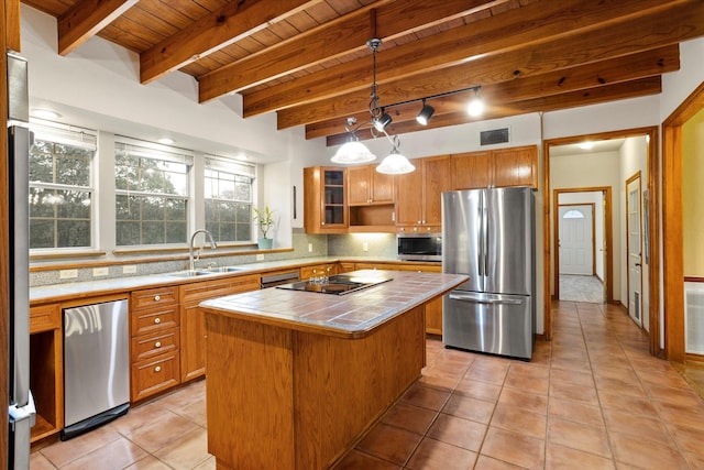 kitchen featuring wood ceiling, tile countertops, a center island, a sink, and stainless steel appliances