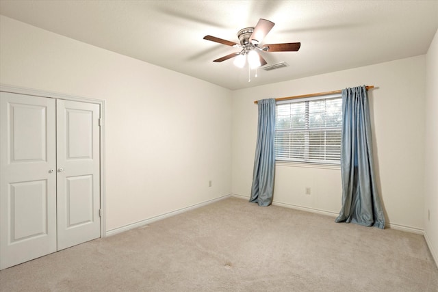 unfurnished room with ceiling fan, visible vents, baseboards, and carpet