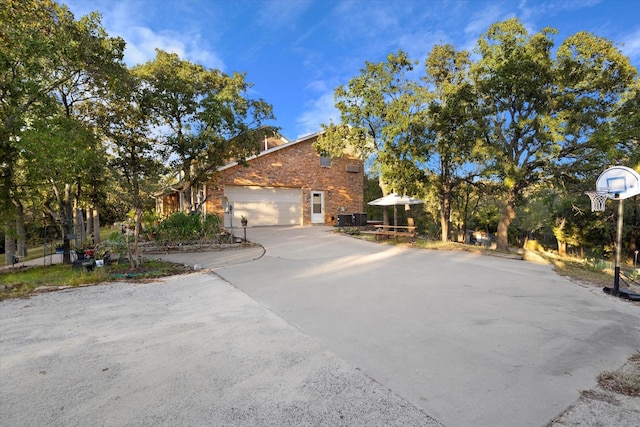 view of property exterior with a garage, concrete driveway, and brick siding