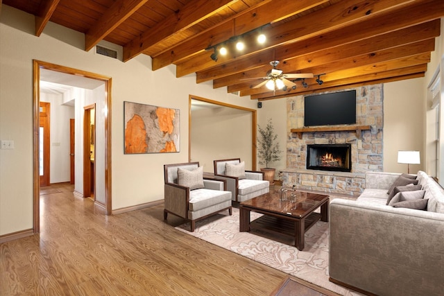 living area featuring wood ceiling, ceiling fan, visible vents, beam ceiling, and wood finished floors