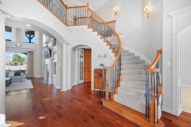 910 Walnut Falls Cir, Mansfield, TX 76063 - foyer with arched walkways, decorative columns, hardwood / wood-style floors, and a towering ceiling