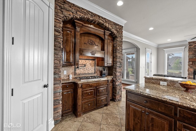 221 Cattail Trl, Benton, LA 71006 - kitchen featuring stainless steel gas cooktop, arched walkways, dark brown cabinetry, and tasteful backsplash