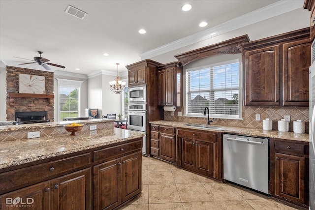 221 Cattail Trl, Benton, LA 71006 - kitchen with visible vents, decorative backsplash, a sink, ceiling fan with notable chandelier, and stainless steel appliances