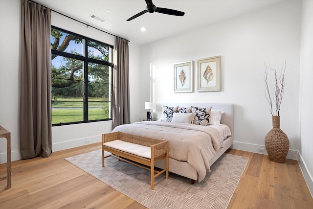 bedroom featuring baseboards, visible vents, and light wood finished floors