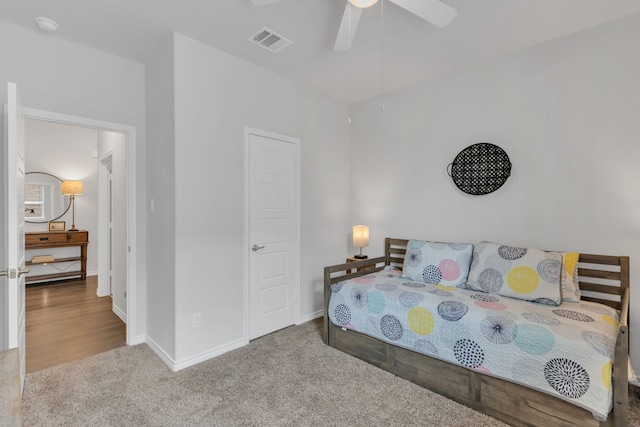 carpeted bedroom with baseboards, a ceiling fan, and visible vents