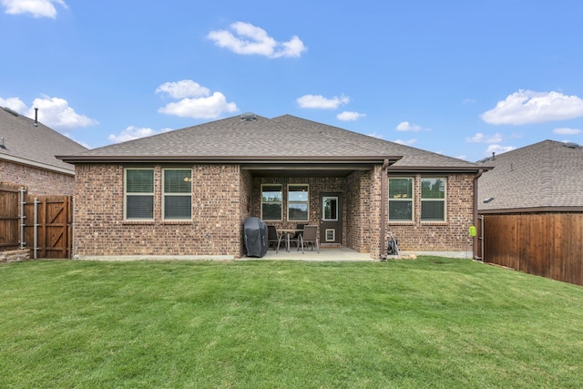 rear view of house with a fenced backyard, a lawn, a patio area, and brick siding