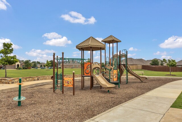 community jungle gym with a lawn and fence
