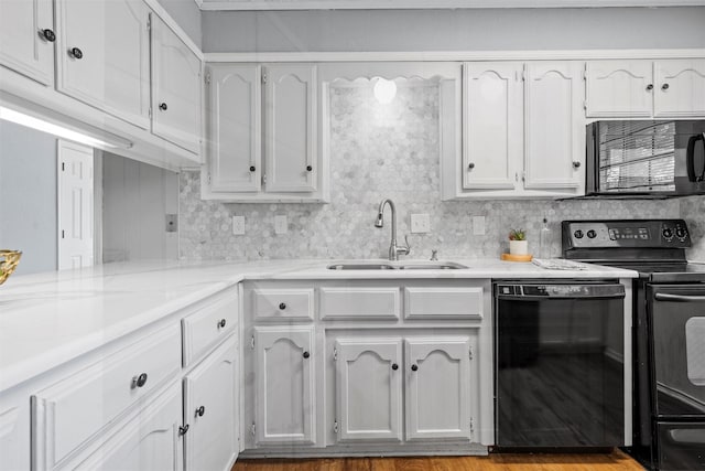 kitchen featuring white cabinetry, light stone countertops, a sink, and black appliances