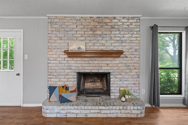 interior details featuring crown molding, a textured ceiling, baseboards, and a brick fireplace