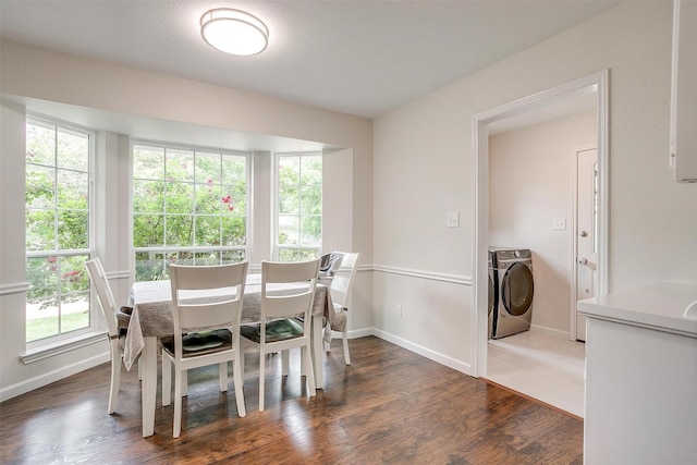 dining space with baseboards, wood finished floors, and separate washer and dryer