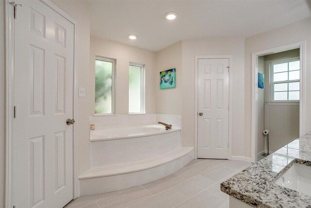 full bath with baseboards, vanity, recessed lighting, and a bath