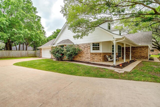 view of property exterior with fence, brick siding, concrete driveway, an attached garage, and a porch