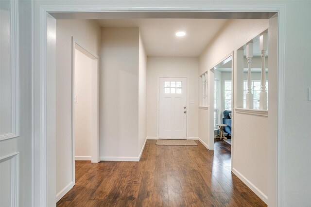foyer featuring baseboards and wood finished floors
