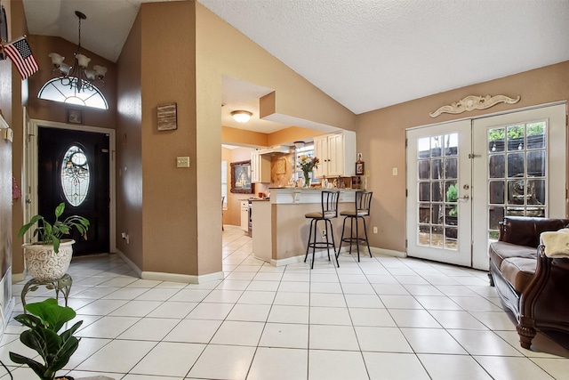2704 Game Lake Dr, Irving, TX 75060 - foyer entrance with baseboards, light tile patterned floors, lofted ceiling, and a notable chandelier