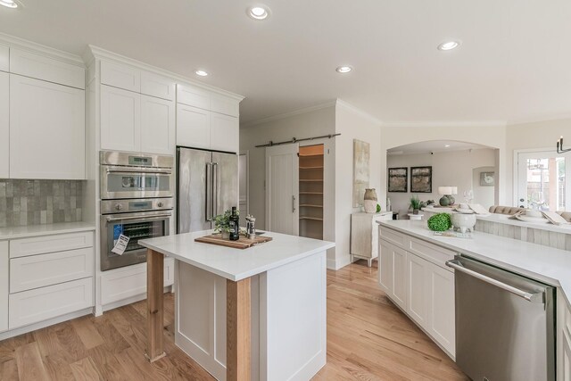 300 Preakness Cir, Southlake, TX 76092 - kitchen featuring wall chimney range hood, appliances with stainless steel finishes, light countertops, ornamental molding, and tasteful backsplash