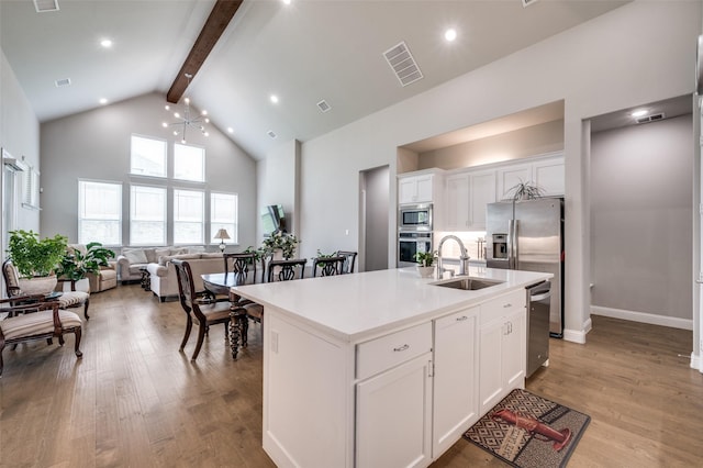 9767 Maple Hill Ln, Frisco, TX 75035 - kitchen with a sink, stainless steel appliances, high vaulted ceiling, beamed ceiling, and white cabinetry